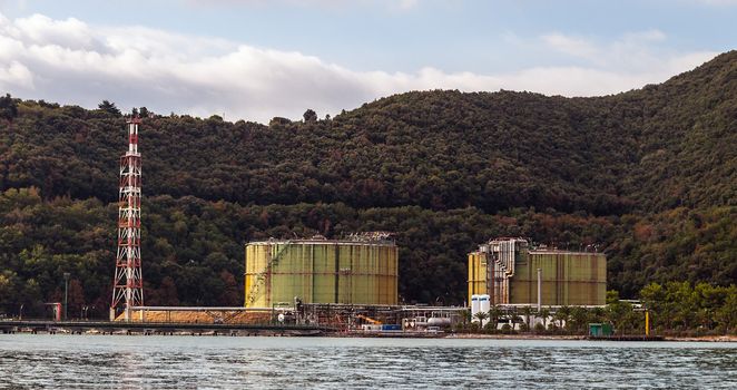 Rusty factory industry container silos over the sea