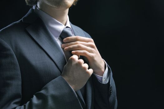 Well dressed business man adjusting his neck tie