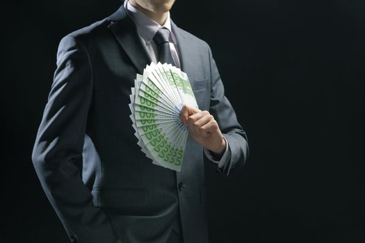 Rich Businessman holding a range of 100 euro banknotes