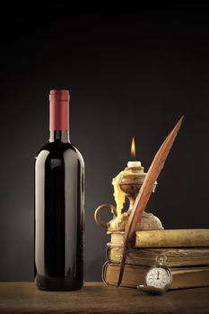 Wine bottle with old books and candle