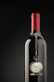 Red wine bottle with pocket watch