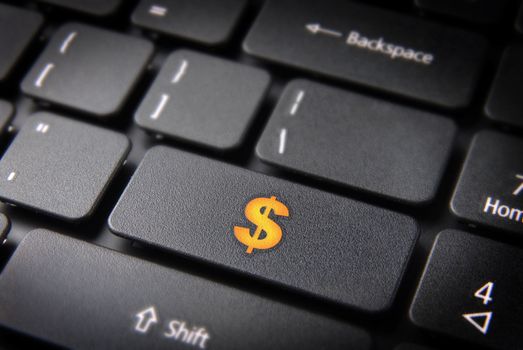 Make money with internet: yellow dollar currency symbol on laptop keyboard. Included clipping path, so you can easily edit it.