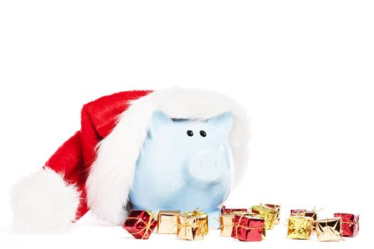piggy bank wearing santas hat with tiny christmas presents on white background