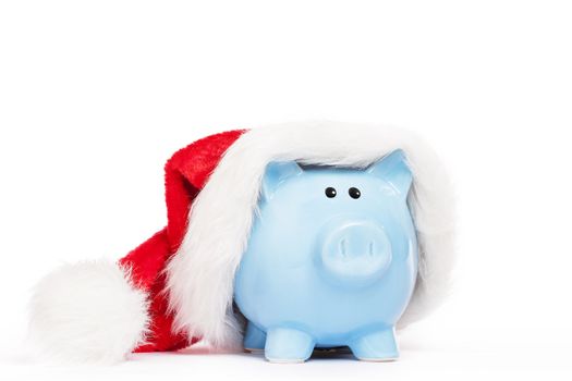 blue piggy bank wearing santas hat on white background