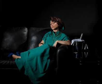 Beautiful girl sitting on a sofa, black background