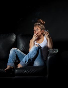 Dark portrait of a woman smoking and alcoholic drinking