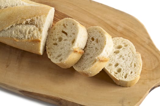 Horizontal and close up image of chopped French bread on a chopping board isolated on white background