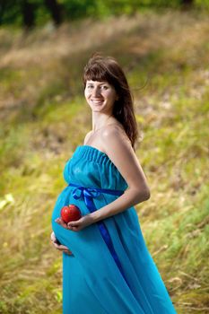 young happy pregnant girl with apple