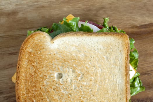 Horizontal image of a delicious ham sandwich over a wooden background