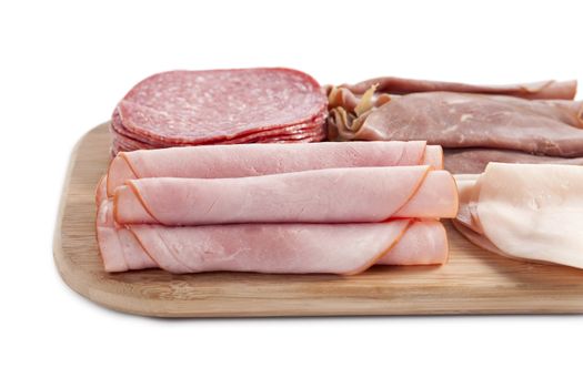 Close up image of ham in wooden plate against white background