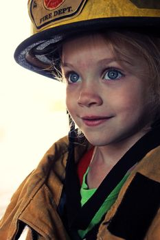 A young girl dressed up as a firefighter