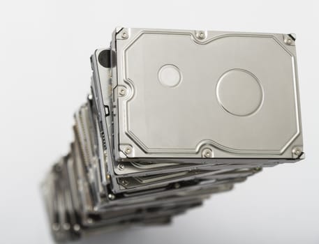 high stack of used hard drives in light background
