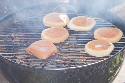 Meat cooking on a charcoal grill in a garden.