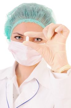 Woman in white coat, gloves, mask and cap with tablet in hands. Isolated on white background. Focus on the tablet.