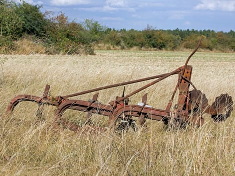 old agricultural machine, abandoned in a field