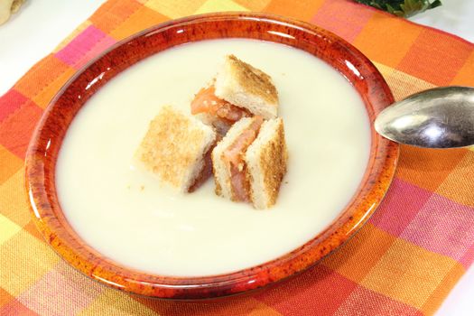 Cream of celery soup with salmon croutons on a checkered napkin