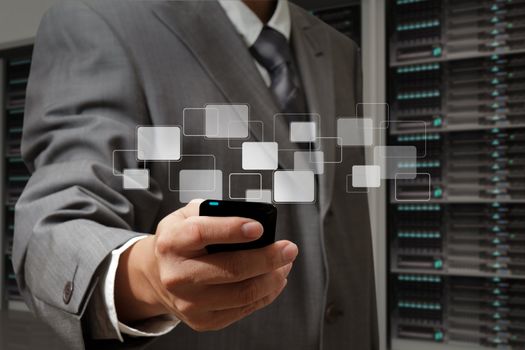 business man holds touch screen mobile phone in server room