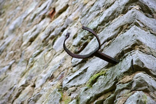 The forged fastening of a pipe on a stone wall