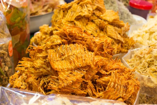 Sweet and spicy dried squid for sale at the market in Thailand.