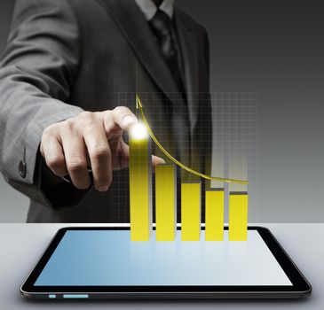 business man hand point to virtual gold graph with tablet computer