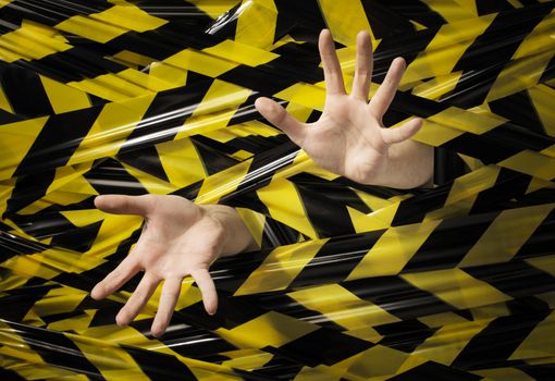 A Man trapped behind yellow and black barrier tape.