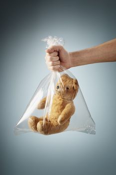 Old generic teddybear in a clear plastic bag.
