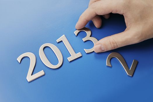 Man changing metallic numbers to year 2013.
