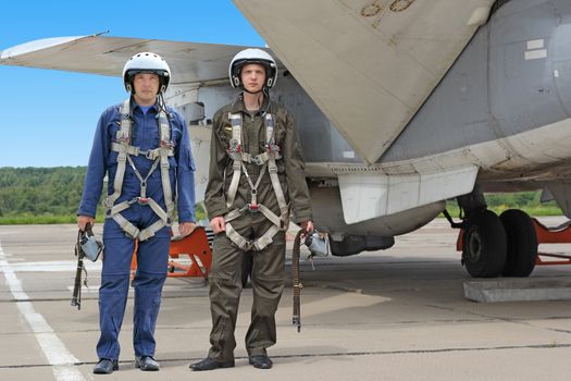 Two military pilot in a helmet near the aircraft