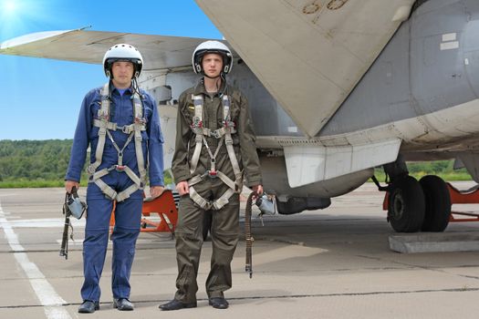 Two military pilot in a helmet near the aircraft