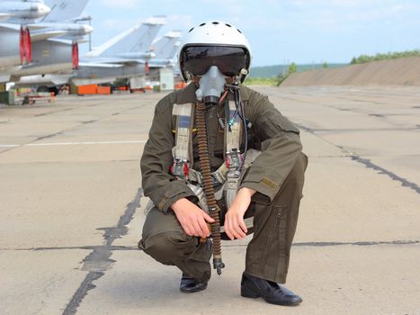 military pilot in a helmet near the aircraft