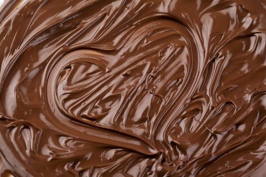 Heart shape symbol made up of dark melted chocolate