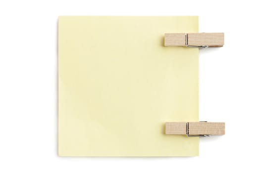 Image of a plain yellow paper with two wooden clip over the white background
