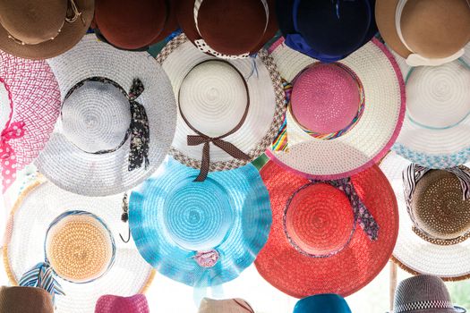 Colorful woven hat hanging on the wall of country shop.