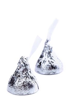 Two chocolate kisses in silver wrapper isolated in a white background