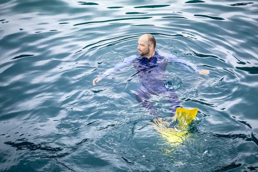 An image of a man swimming in his safetysuit