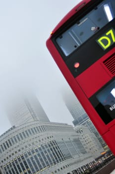 generic image of london city with red bus high business buildings and fog