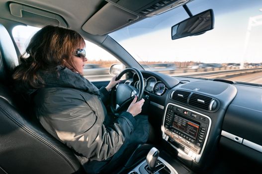 Woman sitting at the steering wheel and driving car