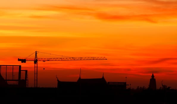 Industrial construction cranes and building at sunrise