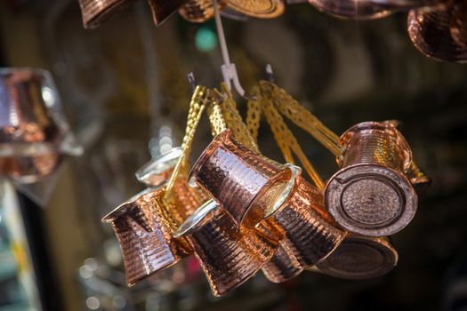 Close up photo of a bunch of copper coffee pots hanged up in a market in Istanbul