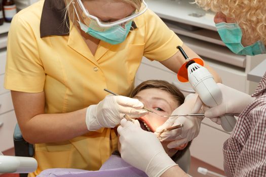 dentist with assistant treating teeth