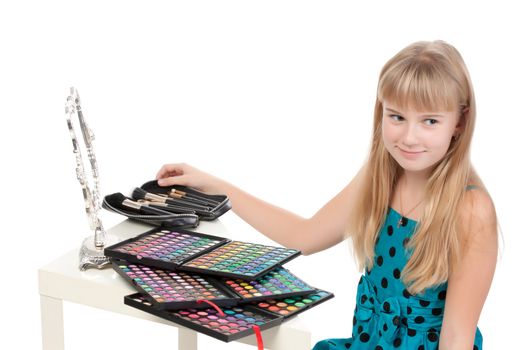 Little girl paints his face makeup, on white background