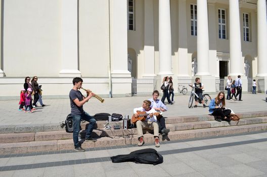 VILNIUS, LITHUANIA - MAY 19: Young unidentified students play pipe and guitar on pavement near Cathedral on May 19, 2012 in Vilnius. Street Music Day.