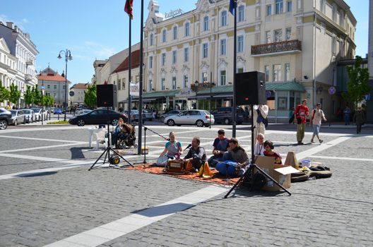 VILNIUS, LITHUANIA - MAY 19: unidentified people playing and singing indian songs sitting on oldtown floor mat carpet on May 19, 2012 in Vilnius. Street Music Day.