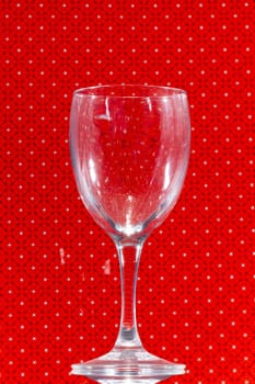 Close up view of transparent glass over a red background.