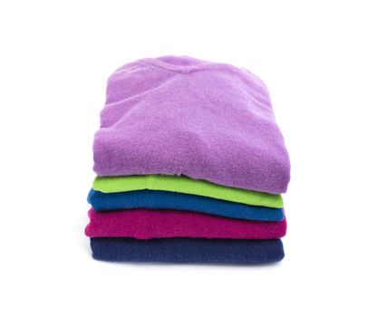 Stack of colorful wool or cashmere sweaters isolated on white