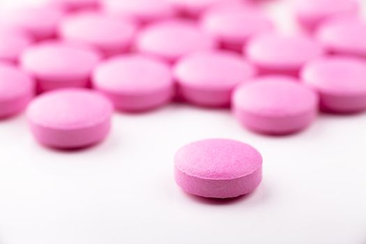 Macro view of pink pills over white background