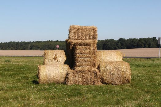 Tractor made of hay bales in a field under a blue sky