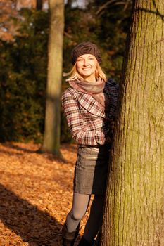 Young woman enjoying sunny day in autumn in the park