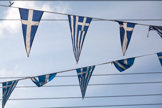 Triangular pennants of the Greek flag on a blue sky