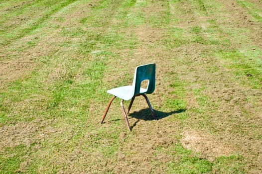 Empty child’s chair in a field